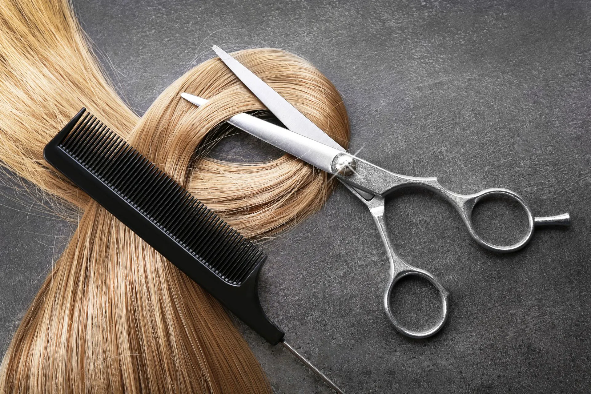 Mèche de cheveux avec ciseaux et peigne.